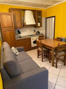uma sala de estar com um sofá e uma mesa numa cozinha em Casa Anita em Badalucco
