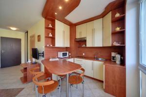 a kitchen with a wooden table and some chairs at Apartamenty Sun Seasons 24 - Portowe in Kołobrzeg