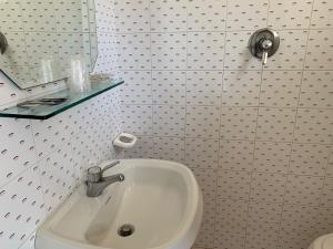 uma casa de banho com um lavatório e um espelho em Hotel Estense em Rimini