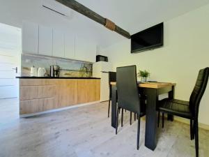 a kitchen and dining room with a table and chairs at Domki Kajuta in Żarnowska