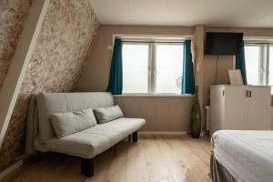 a living room with a couch and a window at Hof van Schoorl in Schoorldam