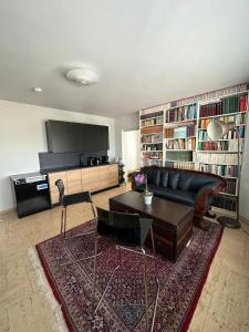 un soggiorno con divano nero e tavolo di Penthouse Frankfurt a Francoforte sul Meno
