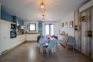 een keuken met een tafel en stoelen in een kamer bij La casa du Lac YourHostHelper in Homps