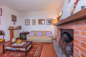 sala de estar con sofá y chimenea en Villino Di Corsanico With View - Happy Rentals, en Massarosa