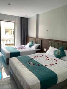 a hotel room with two beds with roses on them at Tuần Châu HQT in Ha Long