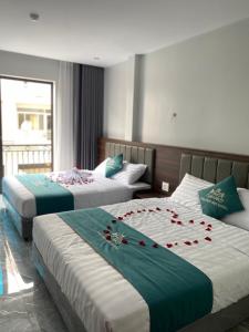 una habitación de hotel con 2 camas con rosas. en Tuần Châu HQT, en Ha Long
