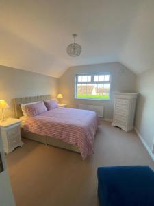1 dormitorio con cama y ventana en St Anthony's Rosslare Strand, en Mervyn