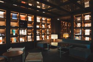 a library with a couch and tables and bookshelves at Marufukuro in Kyoto