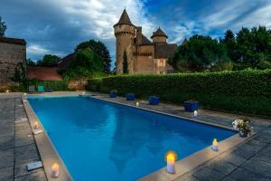 uma piscina com velas em frente a um castelo em Château Garinie 13th Century Medieval castle in the south of France em Lugan