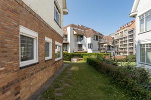 una pasarela entre dos edificios de una ciudad en Les Pinsons - Familievilla met strandzicht én tuin, en Knokke-Heist