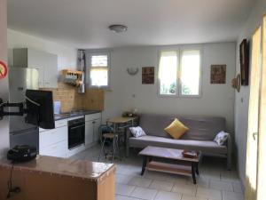 eine Küche und ein Wohnzimmer mit einem Sofa und einem Tisch in der Unterkunft Studio proche mer & climatisé les Anses d'Arlet in Les Anses-dʼArlets