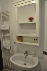 uma casa de banho branca com um lavatório e um espelho em B&B Casa Soresina em Offagna