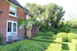 a brick house with a bench in the yard at Dairy Cottage Luxury B&B in Attleborough