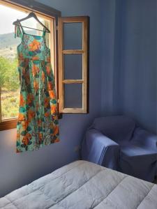 a dress hanging in a room with a window at Studio in Upper Symi in Symi