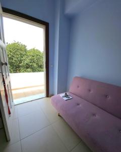 a purple couch in a room with a large window at Studio in Upper Symi in Symi