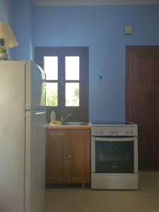 a kitchen with a white stove and a refrigerator at Studio in Upper Symi in Symi