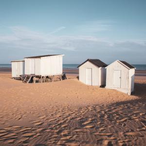加來的住宿－Villa Margrit, escapade en bord de mer et détente dans la piscine chauffée，沙滩上的一排沙滩小屋