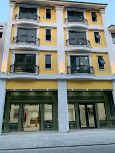a yellow and white building with large windows at Tuần Châu HQT in Ha Long