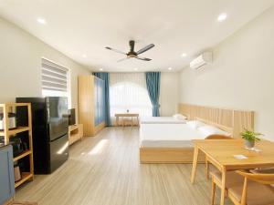 ダナンにあるMoc Son Apartment - Attractive price for week and month stay - Serene Beachside Retreat Near Marble Mountainsのベッドとテーブルのあるホテルの部屋