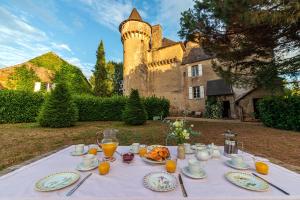 una mesa con platos de comida y un castillo en Château Garinie 13th Century Medieval castle in the south of France, en Lugan
