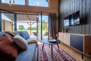 a living room with a couch and a tv and a table at Siedlisko Rusko in Darłowo