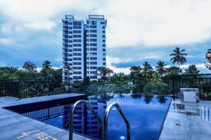 a swimming pool with a tall building in the background at Hotel Ganthera Kandy in Kandy