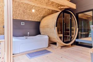 a bathroom with a large tub and a round mirror at enico MtFuji Resort&Glamping in Narusawa