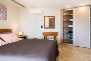 1 dormitorio con cama, escritorio y espejo en Ηοrizon View House, en Nótos