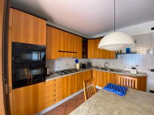 uma cozinha com armários de madeira e uma mesa de jantar em Ca' Rina apartment FREE PARKING LAKE VIEW em Lierna