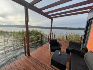 una terraza con sillas y vistas al agua en "B" Domek na wodzie Warmińskie Pompeje, en Barczewko