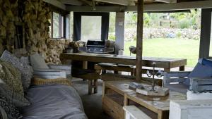 Rainforest Ridge Eco Resort في The Crags: غرفة مع طاولة وكراسي وشواية