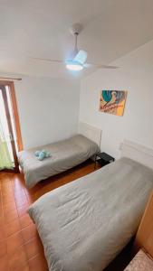 1 dormitorio con 2 camas y ventilador de techo en Gregal Vidaber Adosado, en Oropesa del Mar
