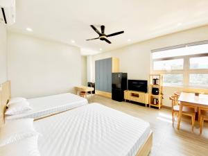 una camera d'albergo con due letti e una sala da pranzo di Moc Son Apartment - Attractive price for week and month stay a Da Nang