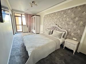 ein Schlafzimmer mit einem Bett und einer Wand mit Blumen in der Unterkunft Villa ACAEM in Chişinău