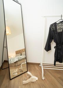 a mirror in a room with a dress and a couch at Downhill Apartment with a Private Terrace in Kaunas