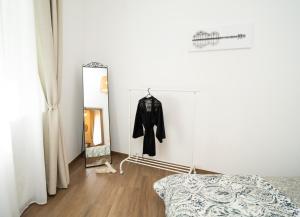 a dressing room with a mirror and a robe on a wall at Downhill Apartment with a Private Terrace in Kaunas