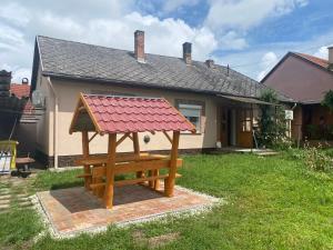 um banco de madeira em frente a uma casa em Inner House em Kőröshegy