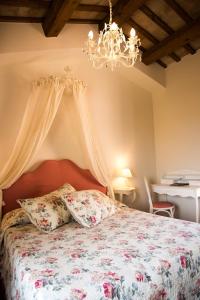 a bedroom with a bed and a chandelier at Casa Di Mi in Serrungarina