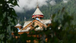 een gebouw met een toren erop bij Alpine Lodge And Stays in Shangarh