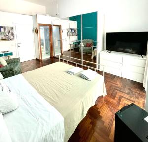 Schlafzimmer mit einem großen weißen Bett und einem Flachbild-TV in der Unterkunft B&B Vista Mare in Neapel