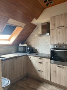 een keuken met houten kasten en een raam bij zen atitude in Sint-Martens-Lennik