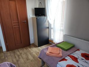 Habitación con cama con sábanas verdes y nevera. en Apartament Wega, en Władysławowo