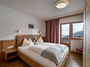 a bedroom with a large bed and a large window at Berghaus Koglmoos in Auffach