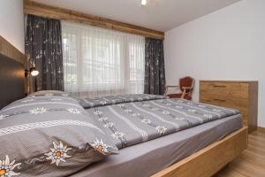 1 dormitorio con 1 cama grande y ventana grande en Haus Floralp en Zermatt