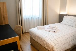 um quarto com uma cama com toalhas em VILLA MANZONI em Cologno al Serio