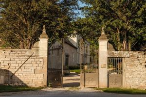 una valla de ladrillo con una puerta y una pared de piedra en Clos des Dames de Lancharre - La Maison Des Vignes, en Chapaize