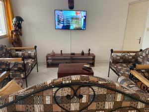 a living room with a couch and a tv on the wall at VILLA SOMONE avec PISCINE PRIVÉE in Somone