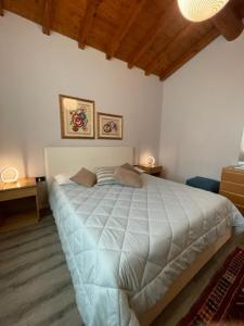 ein Schlafzimmer mit einem großen weißen Bett in einem Zimmer in der Unterkunft La casa in collina in Caprino Veronese