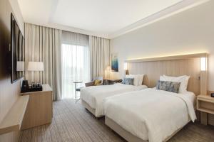 um quarto de hotel com duas camas e uma secretária em Courtyard by Marriott Vilnius City Center em Vilnius