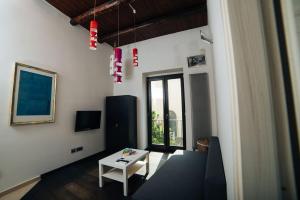 ein Wohnzimmer mit einem Tisch und einem Fenster in der Unterkunft Domus Gisulfo in Salerno